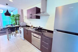 a kitchen with a white refrigerator and a sink at 75 inch TV Sea View Ps5 Game in Manama