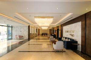 a lobby of a hotel with chairs and a chandelier at 75 inch TV Sea View Ps5 Game in Manama