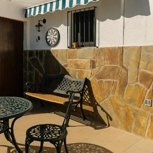 a patio with a bench and a table and a clock at Casa Cueva Hondo in Gáldar