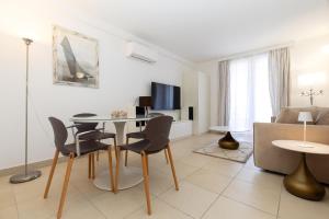 a living room with a table and chairs and a couch at BELLAVISTA apartman Punta in Veli Lošinj