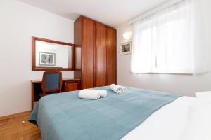 a bedroom with a bed with two towels on it at BELLAVISTA apartman Punta in Veli Lošinj +28 photos