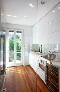 a kitchen with white walls and wooden floors and a sink at K V!STA Penthouse in Centre town - Amazing view! in Como +27 photos