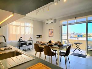 a kitchen and living room with a table and chairs at Marina View in Taʼ Xbiex