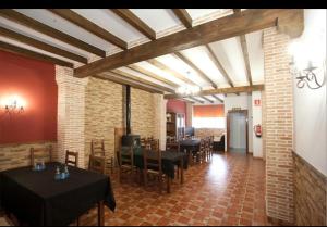 a dining room with tables and chairs and a brick wall at Casa Rural Casole in Castalla