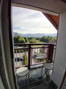 ein Blick von einem Balkon mit zwei Stühlen und einem Tisch in der Unterkunft Appartement cosy calme et propre in Pers-Jussy