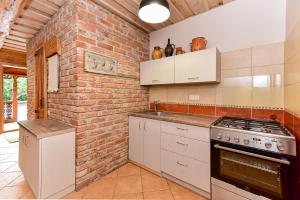 a kitchen with a brick wall and white appliances at House in Krikstonys in Krikštonys