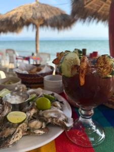 a table with a drink and a plate of food on the beach at Condo Mezcales in Mezcales