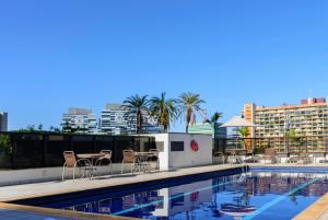 a swimming pool with chairs and tables on a building at Comfort Suites Brasília in Brasília