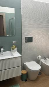 un bagno con un water, un lavandino e uno specchio di Villa Maryam a Agrigento