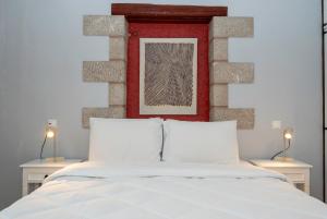 a bedroom with a white bed with a red headboard at Myral Guesthouse in Nafplio