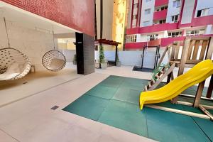 a playground with a yellow slide on a balcony at Studio Terra, Lindo moderno c/ Ar Condicionado in Curitiba