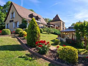 a house with a garden with flowers in the yard at La Roseraie in Vitrac
