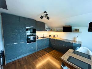 a large kitchen with blue cabinets and a table at Apartment Landscape in Zgornje Gorje