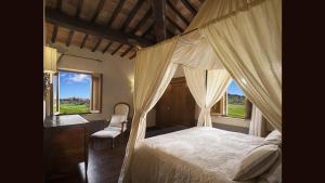 a bedroom with a bed and a desk and windows at L'Olmo in Monticchiello +39 photos