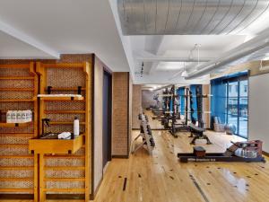 a gym with a row of treadmills and machines at 1 Hotel Central Park in New York