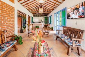a porch with benches and a table with flowers on it at Casa Campestre San Cristóbal cerca al Parque del Café in Montenegro