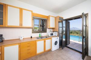 a kitchen with a sink and a washing machine at Villa Elena in Kalathos