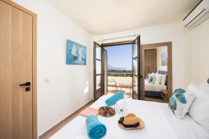 a bedroom with a bed and a room with a view at Villa Elena in Kalathos +30 photos