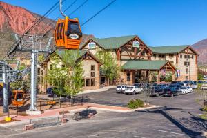 Un tranvía naranja está suspendido sobre un estacionamiento frente a un albergue. en Hotel Glenwood Springs, en Glenwood Springs