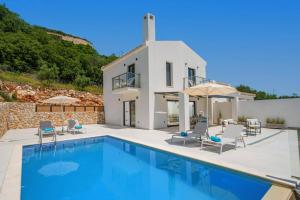 a villa with a swimming pool in front of a house at Villa Lavender Cottage by Villa Plus in Mousata