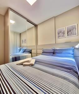 a bedroom with a large bed with a large mirror at Aprazivel Studio no centro de curitiba in Curitiba