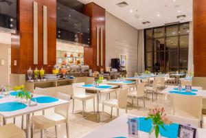 a restaurant with white tables and chairs at Comfort Suites Brasília in Brasília