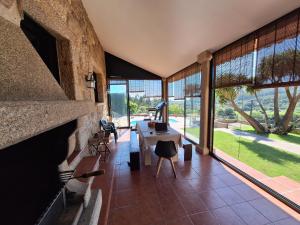 a living room with a large stone wall and a table at Villa Alilacha - Piscina Barbacoa Playa 500 m in Bueu