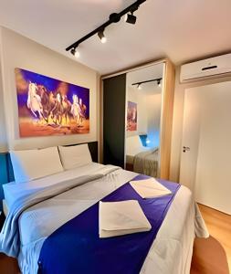 a bedroom with a large bed with a painting on the wall at PRiNCESS, Apto a poucos metros in Curitiba