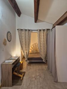 una camera da letto con tende e un letto in una stanza di Joli appartement calme vue montagne dans le centre a Corte