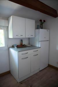 una cucina con mobili bianchi e un frigorifero bianco di Joli appartement calme vue montagne dans le centre a Corte Altre 10 foto