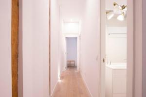 un couloir avec un miroir dans une salle de bain blanche dans l'établissement Apartment Fomento, à Madrid 23 autres photos