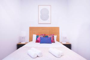 une chambre avec un lit avec deux serviettes dessus dans l'établissement Apartment Fomento, à Madrid