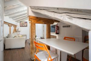 salon z białym stołem i pomarańczowymi krzesłami w obiekcie Minty Stay - Plaza Mayor 1 BD w Madrycie