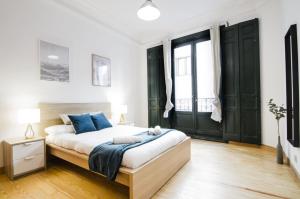 sypialnia z dużym łóżkiem i niebieskimi poduszkami w obiekcie Apartment Fresa, 3 w Madrycie
