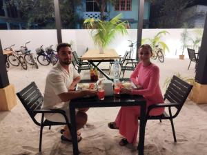 Un hombre y una mujer sentados en una mesa en Hi Heaven Thoddoo, en Thoddoo