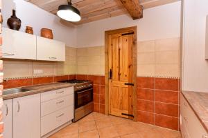a kitchen with white cabinets and a wooden door at House in Krikstonys in Krikštonys +13 photos