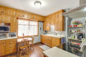 une cuisine avec des armoires en bois et une table et des chaises dans l'établissement 2 Mi to Minnesota River Family Home Near Fishing!, à Montevideo