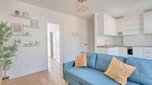 un soggiorno con un divano blu e una cucina di Vitry Vibes City a Vitry-sur-Seine Altre 4 foto