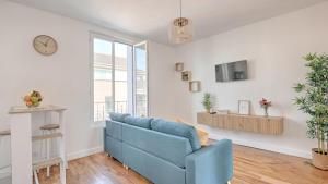 un soggiorno con un divano blu e una TV di Vitry Vibes City a Vitry-sur-Seine