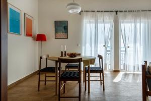 een eetkamer met een tafel en stoelen en een raam bij Finestrini in Preveza +33 foto's