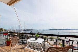 een tafel en stoelen op een balkon met uitzicht op het water bij Finestrini in Preveza
