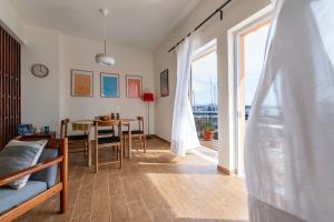 een woonkamer met een tafel en een eetkamer bij Finestrini in Preveza