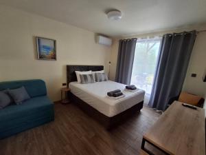 a bedroom with a bed and a blue couch at Къща за гости ,,Ваканция'' in Ezerets +16 photos