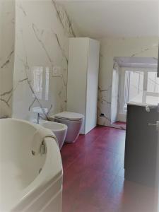 a bathroom with a toilet and a sink and a tub at Centro Stazione Attico in Turin