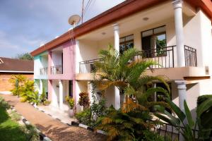 a house with a palm tree in front of it at Romalo Hotel & Apartments in Kigali