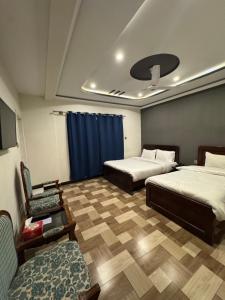 a room with two beds and a couch and a tv at Summit Hotel Skardu in Skardu +17 photos
