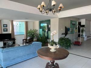 a living room with a blue couch and a table at Hotel Belas Artes in Quixadá