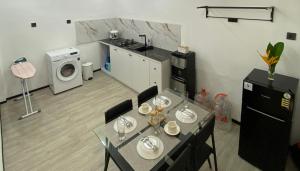 a kitchen with a table and a washing machine at Cleya House Banyuwangi in Giri