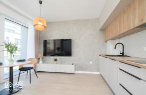 a kitchen with a dining table and a tv on the wall at Milano 18 D&D Apartments in Międzywodzie +18 photos