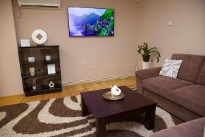 a living room with a couch and a coffee table at Apartman Rooster in Srbobran